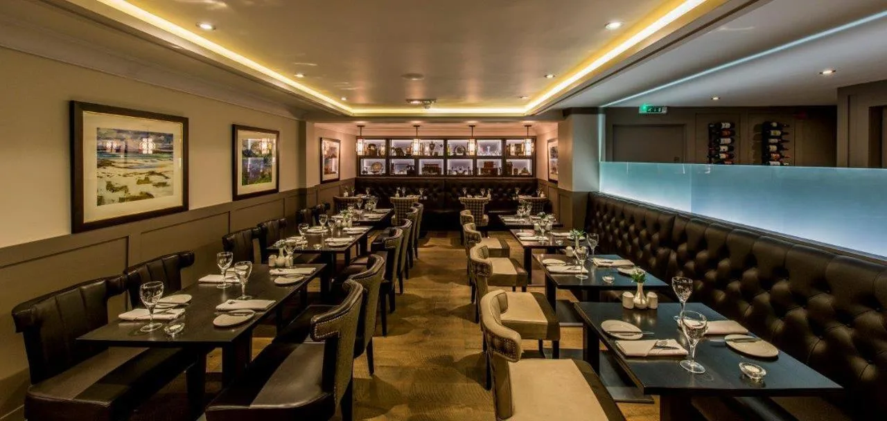 a restaurant with tables and chairs and a bar at The Craighaar Hotel in Aberdeen