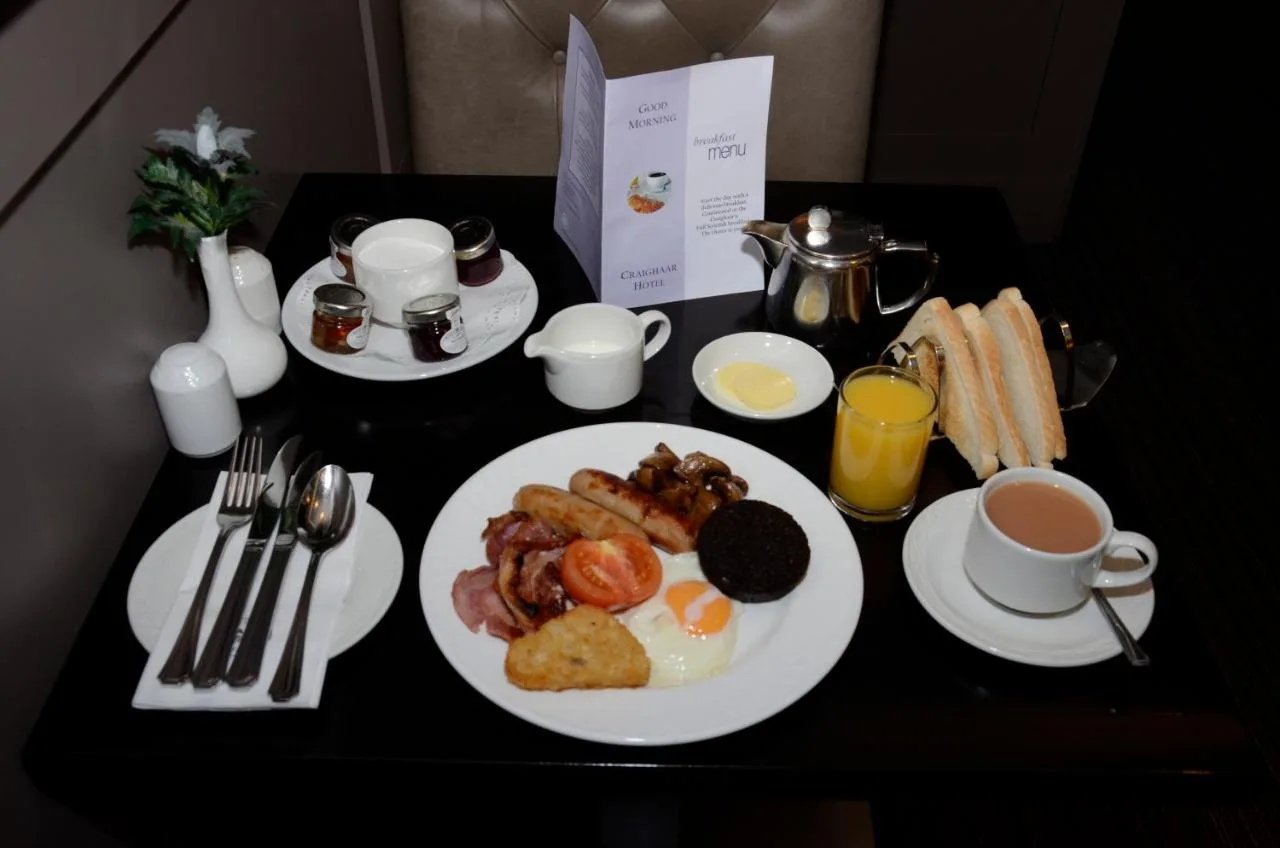 a table with a plate of breakfast food and coffee at The Craighaar Hotel in Aberdeen