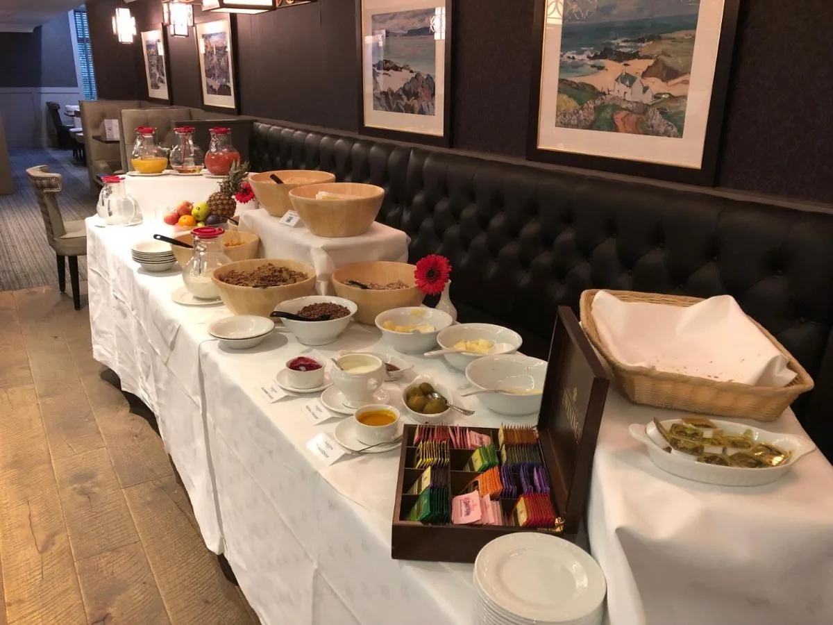 a long white table with bowls of food on it at The Craighaar Hotel in Aberdeen