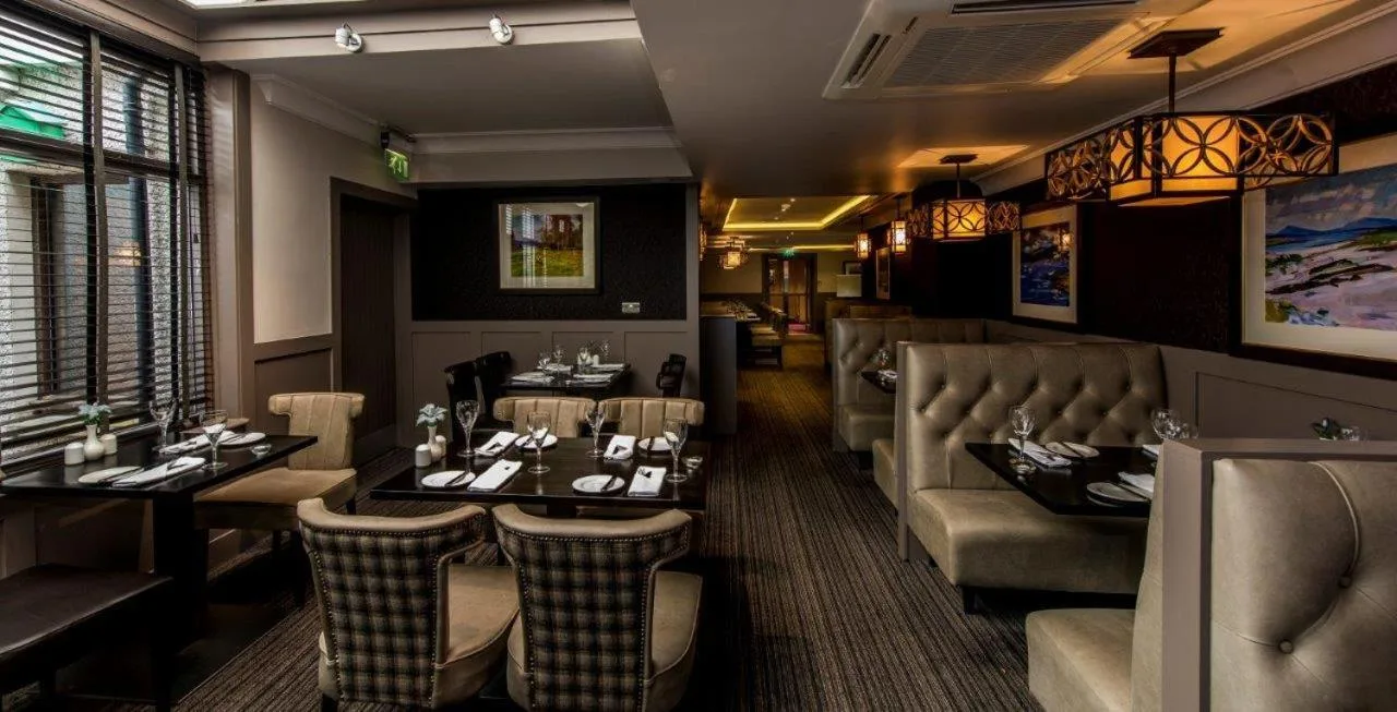 a restaurant with a table and chairs in a room at The Craighaar Hotel in Aberdeen